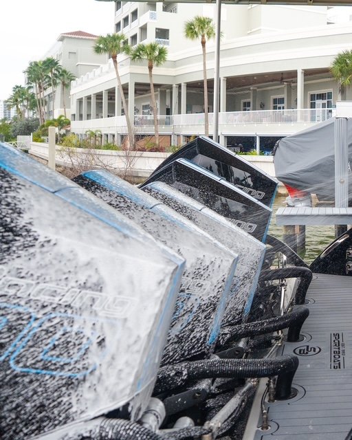 Four Mercury Racing 500 outboards covered in foam during a detail in Naples, Florida